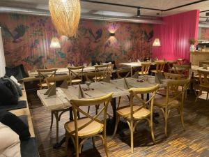 un ristorante con tavoli e sedie in legno e una parete rosa di Rösslerhof Ferienwohnung Nachtweide 