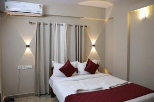 a bedroom with a bed with red and white pillows at Dreams Paradise Airport Residency in Nedumbassery +82 photos