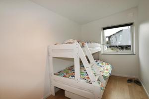Litera blanca en habitación con ventana en Nice villa for 10 people on Styrso, en Styrsö