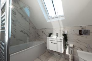 bagno con vasca bianca e lavandino di King's House by Smart Apartments a Southampton