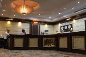 two people standing at a bar in a hotel lobby at Carawan Al Khaleej Hotel Olaya in Riyadh