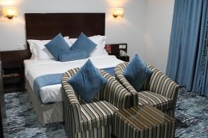 um quarto de hotel com uma cama e duas cadeiras em Carawan Al Khaleej Hotel Olaya em Riade