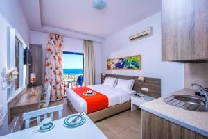 een hotelkamer met een bed en een wastafel bij Astra Village & Suites in Chersonissos