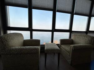 two chairs and a table in front of a large window at Taşliman Otel in Yalova