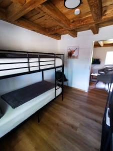 een slaapkamer met een stapelbed in een kamer met houten plafonds bij Rösslerhof Ferienwohnung Stiller Bach 