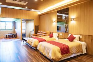 een slaapkamer met 2 bedden en een bank bij LiVEMAX RESORT Sakurajima Sea Front in Tarumizu