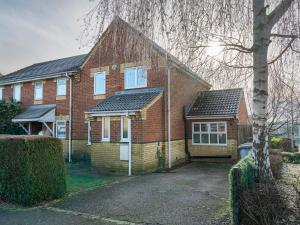 uma casa de tijolos vermelhos com um telhado de gambrel em Pass the Keys Stylish 4 Bedroom Home with Parking in Borehamwood em Borehamwood