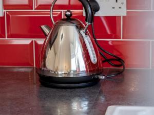 a tea kettle sitting on top of a counter at Pass the Keys Stylish 4 Bedroom Home with Parking in Borehamwood in Borehamwood