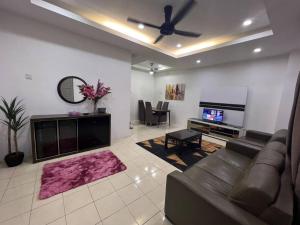 uma sala de estar com um sofá e uma televisão de ecrã plano em RUMAH MURNI by IMPIAN HOMESTAY KLIA-SALAK TINGGI-NILAI em Sepang