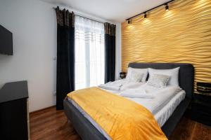 a bedroom with a large bed with a yellow wall at Apartamenty Sun & Snow Resorts G Białka Tatrzańska z sauną in Białka Tatrzańska