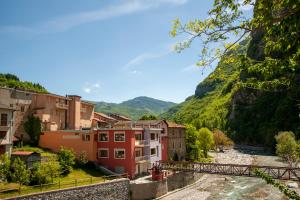 un pueblo con un río y montañas en el fondo en Albergo Ponte di Nava, en Ormea