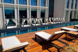 un gruppo di sedie a sdraio e una piscina di Exclusive Apartment With Jacuzzi Rockefeller a El Gallinero