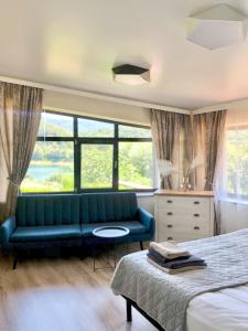 Drive Point (Adventure Lake Resort) في Asparukhovo: غرفة نوم بها أريكة زرقاء وسرير