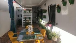 un patio con mesa, sillas y plantas en Casa en pueblo con piscina cerca de Córdoba, en Encinarejo De Córdoba