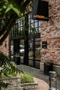 a store front of a brick building with a sign on it at The More Hotel Lund in Lund