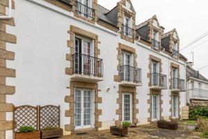 Une rangée de maisons blanches avec balcon dans l'établissement Chez Merlin, à Larmor-Baden