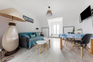 ein Wohnzimmer mit einem blauen Sofa und einem Tisch in der Unterkunft Chez Merlin in Larmor-Baden