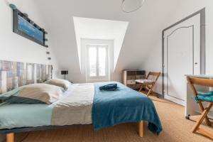 ein Schlafzimmer mit einem großen Bett und einem Schreibtisch in der Unterkunft Chez Merlin in Larmor-Baden