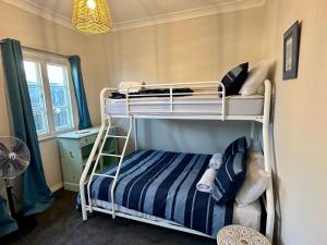 a bedroom with two bunk beds and a fan at Beach Shack Bunbury in Bunbury
