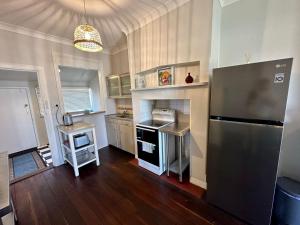 uma cozinha com um frigorífico em aço inoxidável e pisos em madeira em Beach Shack Bunbury em Bunbury