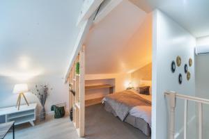 an attic bedroom with a bed and a staircase at Le Cocon des Marins in Châteauroux