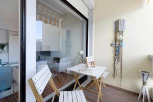 a dining room with a table and chairs and a window at Apartamento T1 - Tróia Resort in Troia