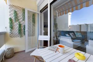 特羅亞的住宿－Apartamento T1 - Tróia Resort，小阳台配有桌子和沙发