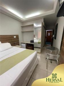 a hotel room with a large bed and a desk at Herval Park Hotel in Ponta Porã