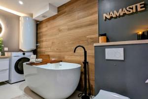 ein Badezimmer mit einer Badewanne und einer Waschmaschine in der Unterkunft Le Petit Bali in Sélestat