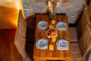 uma mesa com copos de sumo de laranja e pratos em Carob Cottage em Elounda