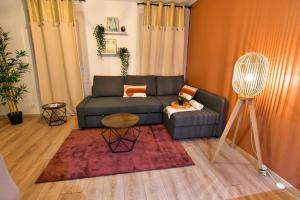 ein Wohnzimmer mit einem Sofa und einem Tisch in der Unterkunft Le Petit Bali in Sélestat