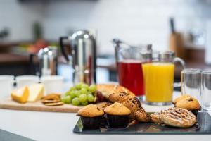 a table with a plate of muffins and fruit and juice at Liverpool Georgian Town House Catharine St in Liverpool