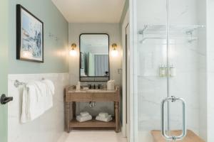 a bathroom with a sink and a shower with a mirror at The Palmetto Hotel, Charleston in Charleston