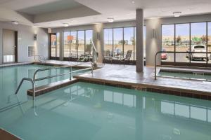 a swimming pool with blue water in a building at Wingate by Wyndham - Bismarck in Bismarck