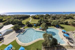 an overhead view of a pool with the ocean in the background at Ramada By Wyndham Marcoola Beach in Marcoola