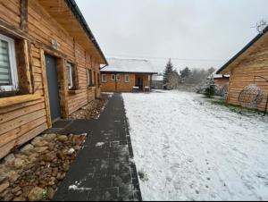 un vialetto coperto da neve di fronte a una casa di Agroturystyka Siedlisko 