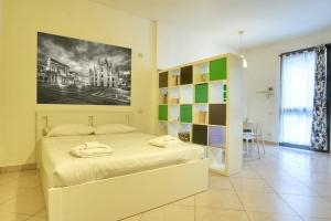 1 dormitorio con 1 cama blanca y una pintura en la pared en Il Giardino del naviglio-Studio en Milán