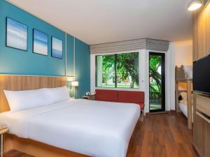 a bedroom with a white bed and a window at Hotel Ibis Samui Bophut in Bophut