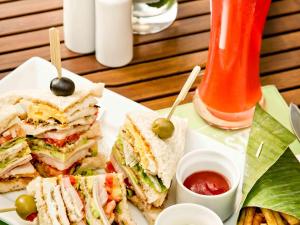 a white plate with a sandwich with olives and ketchup at Hotel Ibis Samui Bophut in Bophut