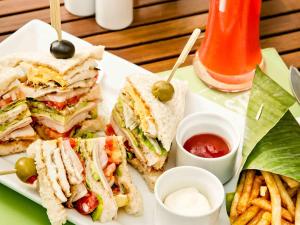 a plate with a sandwich and french fries and ketchup at Hotel Ibis Samui Bophut in Bophut