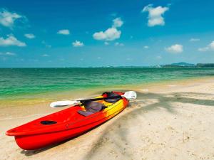 a red and yellow kayak sitting on the beach at Hotel Ibis Samui Bophut in Bophut