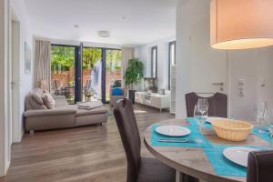 a dining room and living room with a table and chairs at Toms Kajute in Heiligenhafen