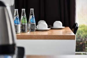 a wooden table with four bottles and plates on it at Sleepinn Gdansk Airport in Gdańsk-Rębiechowo