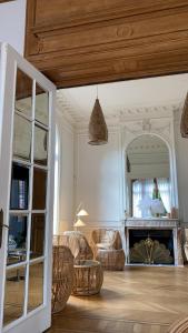 sala de estar con sillas de mimbre y chimenea en La Villa Barbieux, en Roubaix