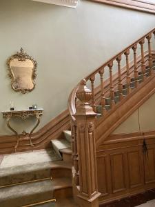 un escalier en bois avec un miroir mural dans l'établissement La Villa Barbieux, à Roubaix