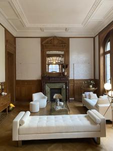 a living room with a white couch and a fireplace at La Villa Barbieux in Roubaix