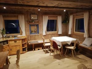 a dining room with a table and chairs and windows at Landhaus Löberbauer in Tux