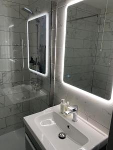 a white bathroom with a sink and a mirror at Port Pour Deux in Portrush +22 photos