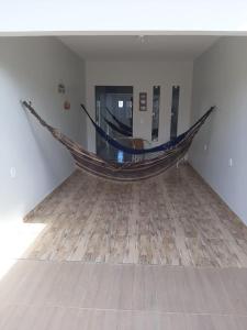 a hammock in a room with a wooden floor at Casa em São Miguel dos Milagres in São Miguel dos Milagres
