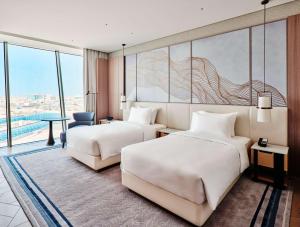 um quarto de hotel com duas camas e uma grande janela em Grand Hyatt Kuwait em Kuwait